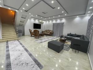 a living room with a couch and a tv at La Dolce Villa with Private Pool in Borg El Arab +11 photos