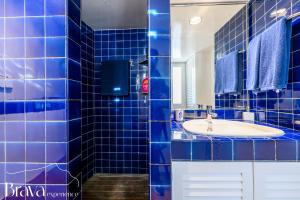 a blue tiled bathroom with a sink and a mirror at Es Forn - Vistas panorámicas a la bahía I terraza privada I 5 dormitorios I chimenea I centro histórico I Brava Experience in Cadaqués