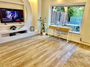 a living room with a tv and a wooden floor at Im Point von Kiel City in Kiel