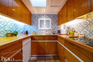 a kitchen with wooden cabinets and blue tiles at Es Forn - Vistas panorámicas a la bahía I terraza privada I 5 dormitorios I chimenea I centro histórico I Brava Experience in Cadaqués