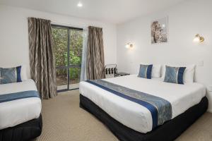 a hotel room with two beds and a window at ASURE Phoenix Motor Inn in Blenheim +33 photos