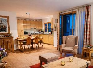 a kitchen and living room with a table and chairs at Laax Cozy Apartment - Ski Bus - Fireplace in Laax