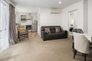 a living room with a couch and a kitchen at ASURE Phoenix Motor Inn in Blenheim