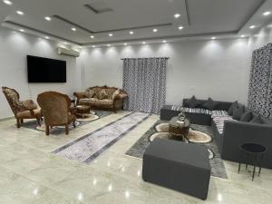 a living room with couches and a flat screen tv at La Dolce Villa with Private Pool in Borg El Arab