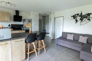a kitchen and a living room with a couch at Vue lac - T2 rénové - Parking - 4 pers in Gap