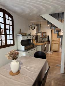 a kitchen with a table with a vase of flowers on it at Logement Sainte-Énimie in Sainte-Énimie +6 photos