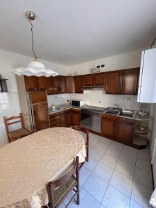 a kitchen with wooden cabinets and a table in it at Casa vacanze Orchidea in Treviolo +14 photos