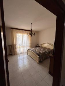 a bedroom with a bed and a chandelier at Casa vacanze Orchidea in Treviolo