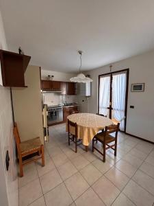 a kitchen and dining room with a table and chairs at Casa vacanze Orchidea in Treviolo