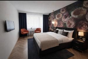 a bedroom with a large bed with a painting on the wall at Hotel Schwanenweiher Bad Bertrich in Bad Bertrich