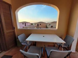 a table and chairs in a room with a window at Sardegna selvaggia a due passi dal mare in Vignola Mare