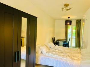 a bedroom with a white bed and a dining room at COZY ROOM in Helsingborg in Helsingborg