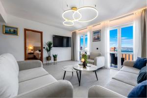 a living room with white furniture and a chandelier at Villa Nick in Cavtat