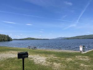 a picnic table and a bench next to a lake at Fun on Moosehead Lake in Greenville Junction