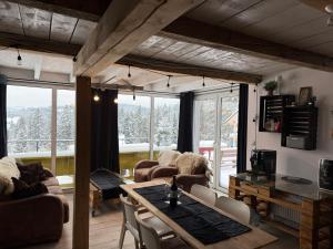 ein Wohnzimmer mit Tisch und Stühlen in der Unterkunft LUCE Chata in Nieledwia