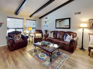 a living room with leather furniture and a table at Billy The Kid at Aspen Run 4A in Ruidoso