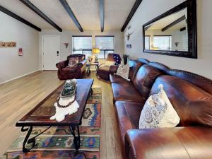 a living room with a leather couch and a table at Billy The Kid at Aspen Run 4A in Ruidoso