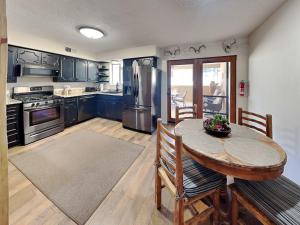 a kitchen with a wooden table and a table and chairs at Billy The Kid at Aspen Run 4A in Ruidoso +19 photos