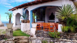 a house with a table and chairs and the ocean at Pousada Rainha das Águas in Ilhéus