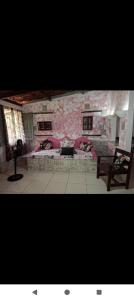 a living room with a pink couch and a fireplace at Pousada Rainha das Águas in Ilhéus