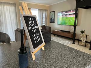 a chalkboard sign on a table in a living room at The Grey Ivory in Port Alfred