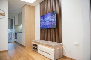 a living room with a television on a wall at Phenix Apartments Lux Parking FREE in Podgorica