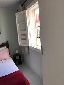 a bedroom with a bed and a window at Quarto Real - Centro Histórico in Diamantina +2 photos