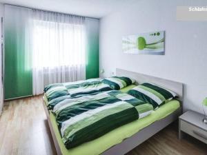 a bedroom with a bed with green and white sheets at Apartment Fe-Wohnung Augsburg by Interhome in Augsburg +19 photos