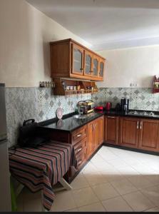 a kitchen with wooden cabinets and a black counter top at Suite Home martil in Martil