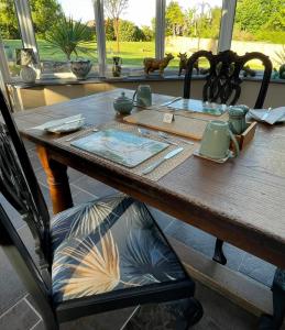 a wooden table with a chair at a table with at Treveighan Farmhouse in Saint Teath +41 photos