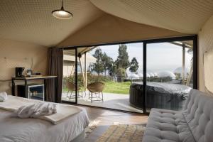 a bedroom with a bed and a large glass window at NaturHotel in Cuenca