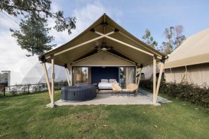 a gazebo with a bed and chairs in it at NaturHotel in Cuenca