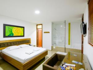 1 dormitorio con 1 cama y TV en una habitación en Hotel Monarca, en Itagüí