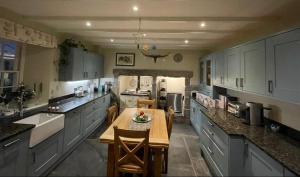 a large kitchen with a wooden table in it at Treveighan Farmhouse in Saint Teath