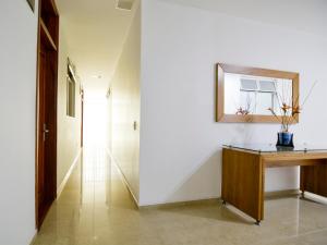 a hallway with a desk and a mirror on a wall at Hotel Monarca in Itagüí