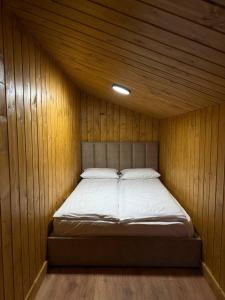 a bedroom with a bed in a wooden wall at Мої Гори in Pilipets +16 photos