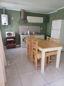 a kitchen with a wooden table and chairs in it at il Mandarino in Bahía Blanca