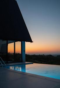 a swimming pool with a sunset in the background at Villa Gaia Novi Grad in Jablanica