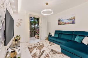 a living room with a blue couch and a tv at luxury apartament in Viareggio