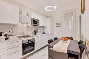 a kitchen with white appliances and a table and chairs at luxury apartament in Viareggio
