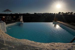 a large swimming pool with the sun in the background at Balcones de Piedad in Los Balcones