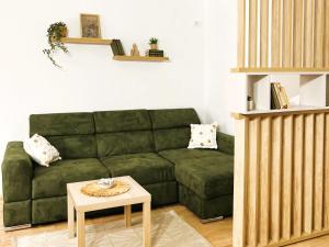 a living room with a green couch and a table at Vikend kuca pod lipom in Rudnik