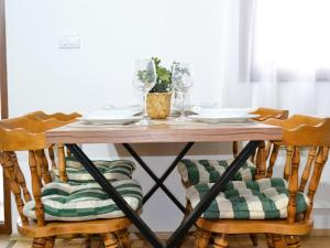 a dining room table with chairs with plates and glasses at Vikend kuca pod lipom in Rudnik