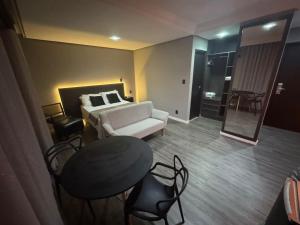 a living room with a bed and a table and chairs at Manaus Hotéis Millenium - Flat 804 in Manaus +8 photos
