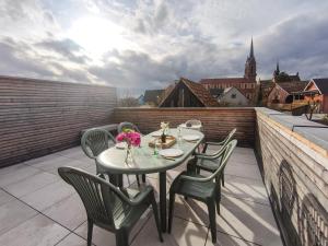 a table and chairs on the roof of a balcony at Mackenheim - Parenthèse détente en Alsace - Terrasse & Parking in Mackenheim