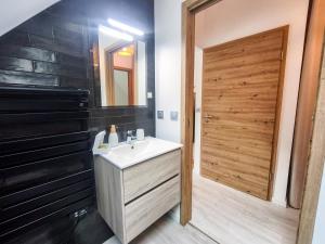 a bathroom with a sink and a wooden door at Mackenheim - Parenthèse détente en Alsace - Terrasse & Parking in Mackenheim +14 photos