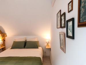 a bedroom with a bed and pictures on the wall at Mackenheim - Parenthèse détente en Alsace - Terrasse & Parking in Mackenheim