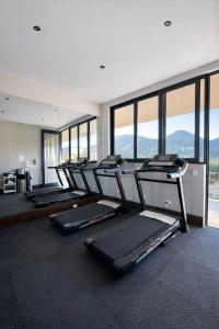 a gym with a row of treadmills and windows at Hotel Flores de Sal-Valle de Guadalupe in Valle de Guadalupe