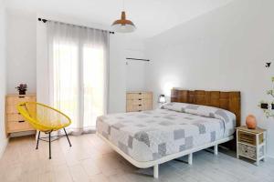 a bedroom with a large bed and a yellow chair at Alojamiento Simon 1 Murcia in Murcia