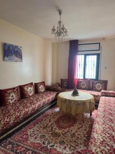 a living room with a couch and a table at Suite Home martil in Martil